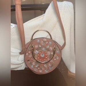 Gorgeous whimsical light pink/beige crossbody with pastel colored floral design.